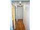 Bright hallway with hardwood floors and white walls, leading to various rooms at 13316 Alex Mill Dr, Pineville, NC 28134