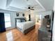 Spacious main bedroom with tray ceiling, hardwood floors, a ceiling fan, and ensuite bathroom at 13316 Alex Mill Dr, Pineville, NC 28134