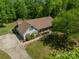 Aerial view of a home with a large driveway and lush green landscaping in a wooded setting at 1374 Weatherby Dr, Salisbury, NC 28146