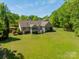 Sprawling backyard features lush green lawn, mature trees, and a charming patio at 1374 Weatherby Dr, Salisbury, NC 28146