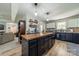 Spacious kitchen with a wooden island, dark cabinets, and modern appliances, open to the living area at 1374 Weatherby Dr, Salisbury, NC 28146