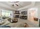 Cozy living room with a fireplace, a mounted TV, and a view into the sunroom and hallway at 1374 Weatherby Dr, Salisbury, NC 28146