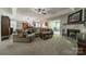 Spacious living room with a fireplace, large sofa, and seamless transition to the sunroom and dining area at 1374 Weatherby Dr, Salisbury, NC 28146