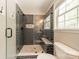 Modern shower with dark tiling, window, built-in bench, and frameless glass doors at 1374 Weatherby Dr, Salisbury, NC 28146