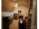 View of the unfinished attic with bare plywood, wood beam framing, and ceiling fan at 14131 Lucia Riverbend Hwy, Mount Holly, NC 28120