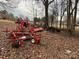 A collection of farm equipment is found in a wooded area surrounded by fallen leaves and bare trees at 14131 Lucia Riverbend Hwy, Mount Holly, NC 28120