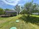 Exterior shot of a cozy backyard with a home, lush green grass, and mature shade trees at 155 Ervin Loop, China Grove, NC 28023