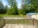 Inviting backyard view from the deck, featuring a spacious lawn, mature trees, and a convenient storage shed at 155 Ervin Loop, China Grove, NC 28023