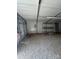 Inside the metal storage shed, showing the gravel floor, electrical box, lighting, and metal shelving at 155 Ervin Loop, China Grove, NC 28023
