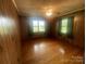 Bedroom filled with natural light, highlighting wood-paneled walls and hardwood flooring at 1620 Moss Springs Rd, Albemarle, NC 28001