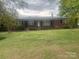Charming one-story brick home featuring a well-manicured front lawn and mature trees at 1620 Moss Springs Rd, Albemarle, NC 28001