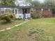 Charming front yard with a brick house, a stone walkway, and a quaint white picket fence at 1620 Moss Springs Rd, Albemarle, NC 28001