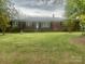 Charming one-story brick home featuring a well-manicured front lawn and mature trees at 1620 Moss Springs Rd, Albemarle, NC 28001