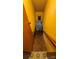 Stairs leading to the basement from the main level, featuring yellow walls and vintage tile at 1684 Montevista Dr, Shelby, NC 28150
