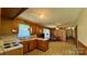 Open kitchen and living area with wood paneled walls and vintage flooring at 1684 Montevista Dr, Shelby, NC 28150