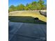 Fenced backyard with large lawn and surrounding green trees, as viewed from the concrete patio at 1905 Yellow Daisy Dr, Matthews, NC 28104