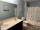 Well-lit bathroom featuring double sinks, a large mirror, and a shower with a floral curtain at 1905 Yellow Daisy Dr, Matthews, NC 28104