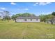 View of the rear exterior showing the home's siding, roof, and a large, grassy yard at 218 Valleybrook Ln, Troutman, NC 28166