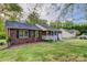 Traditional brick house with a well-kept lawn, mature trees, and a detached garage for ample parking at 221 Delview Dr, Cherryville, NC 28021