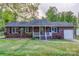 Charming brick home featuring a well-maintained front yard and covered porch with beautiful landscaping at 221 Delview Dr, Cherryville, NC 28021