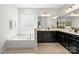 A large soaking tub sits next to a double vanity with dark cabinetry and cream countertops at 2333 Talon Point Cir, Fort Mill, SC 29715