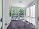 View of the screened porch with dark stained floor, white rails and green trees in the background at 2333 Talon Point Cir, Fort Mill, SC 29715