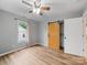 Bedroom features wood-look flooring, a ceiling fan, and a sliding barn door for closet access at 268 Jefferson Ne Ct, Concord, NC 28025