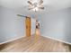 This bedroom features wood-look flooring, a ceiling fan, and a sliding barn door for closet access at 268 Jefferson Ne Ct, Concord, NC 28025