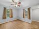 Bright bedroom features wood-look flooring, ceiling fan, and two windows with lovely outdoor views at 268 Jefferson Ne Ct, Concord, NC 28025