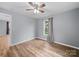 Bedroom features wood-look flooring, a ceiling fan, and a window with views of the outdoors at 268 Jefferson Ne Ct, Concord, NC 28025