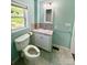 Updated bathroom with tiled backsplash, toilet, vanity, and marble-look flooring at 2724 Peachtree Rd, Statesville, NC 28625