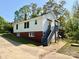 Charming two-story home featuring brick foundation, white siding, and a cozy second story deck at 2724 Peachtree Rd, Statesville, NC 28625