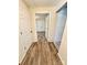 Hallway with wood-look flooring, white doors and trim, and neutral walls at 2724 Peachtree Rd, Statesville, NC 28625