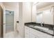Modern bathroom with white cabinets, black granite countertop, and doorway leading to the bedroom at 3004 Village Ridge Dr, Gastonia, NC 28056