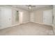 Bright bedroom with neutral carpet, a ceiling fan, and an ensuite bathroom with a mirrored door at 3004 Village Ridge Dr, Gastonia, NC 28056