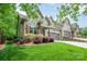 Close-up of the home's facade, highlighting the stone detailing, landscaping, and well-maintained lawn at 3004 Village Ridge Dr, Gastonia, NC 28056