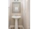 Clean half bath with pedestal sink, framed mirror, and neutral color scheme at 3004 Village Ridge Dr, Gastonia, NC 28056