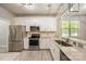 Modern kitchen featuring white cabinets, stainless steel appliances, granite counters, and bright natural lighting at 3004 Village Ridge Dr, Gastonia, NC 28056