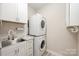 Functional laundry room featuring a sink, granite countertops, and stacked washer/dryer units at 3004 Village Ridge Dr, Gastonia, NC 28056