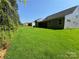 View of the backyard featuring lush green lawn, tree line, and home exterior at 3022 Cedar Falls Dr # 16, Waxhaw, NC 28173