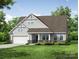 Charming home features a covered porch with stone accents, a two-car garage, and manicured lawn at 3022 Cedar Falls Dr # 16, Waxhaw, NC 28173