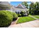 Well-maintained townhome with a lush green lawn and landscaped bushes leading to the front porch and entrance at 3219 Cottage Rose Ln, Rock Hill, SC 29732