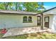 Home exterior with a white brick wall, dark brown trim, and a concrete patio at 3300 Bonaire Dr, Charlotte, NC 28208