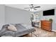 A well-lit bedroom with a desk area, hardwood floors, and a ceiling fan providing a comfortable living space at 3300 Bonaire Dr, Charlotte, NC 28208