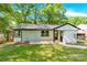 Inviting home exterior with lush green lawn and natural light shining through mature trees at 3300 Bonaire Dr, Charlotte, NC 28208