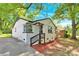 Side view of a white brick home with dark trim and a cozy entranceway, accented with fresh mulch and greenery at 3300 Bonaire Dr, Charlotte, NC 28208