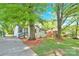 Charming white brick home framed by mature trees and a well-kept lawn, offering a serene and inviting outdoor space at 3300 Bonaire Dr, Charlotte, NC 28208
