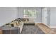 Comfortable living room with a large sofa, hardwood floors, and a bright window offering a cozy space at 3300 Bonaire Dr, Charlotte, NC 28208