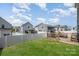 The fenced backyard features a wooden deck, a green lawn, and residential homes under a cloudy sky at 334 Bluebonnet Dr, Salisbury, NC 28146