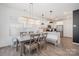 Open dining area with modern lighting fixtures, wood flooring, and access to the kitchen area at 334 Bluebonnet Dr, Salisbury, NC 28146